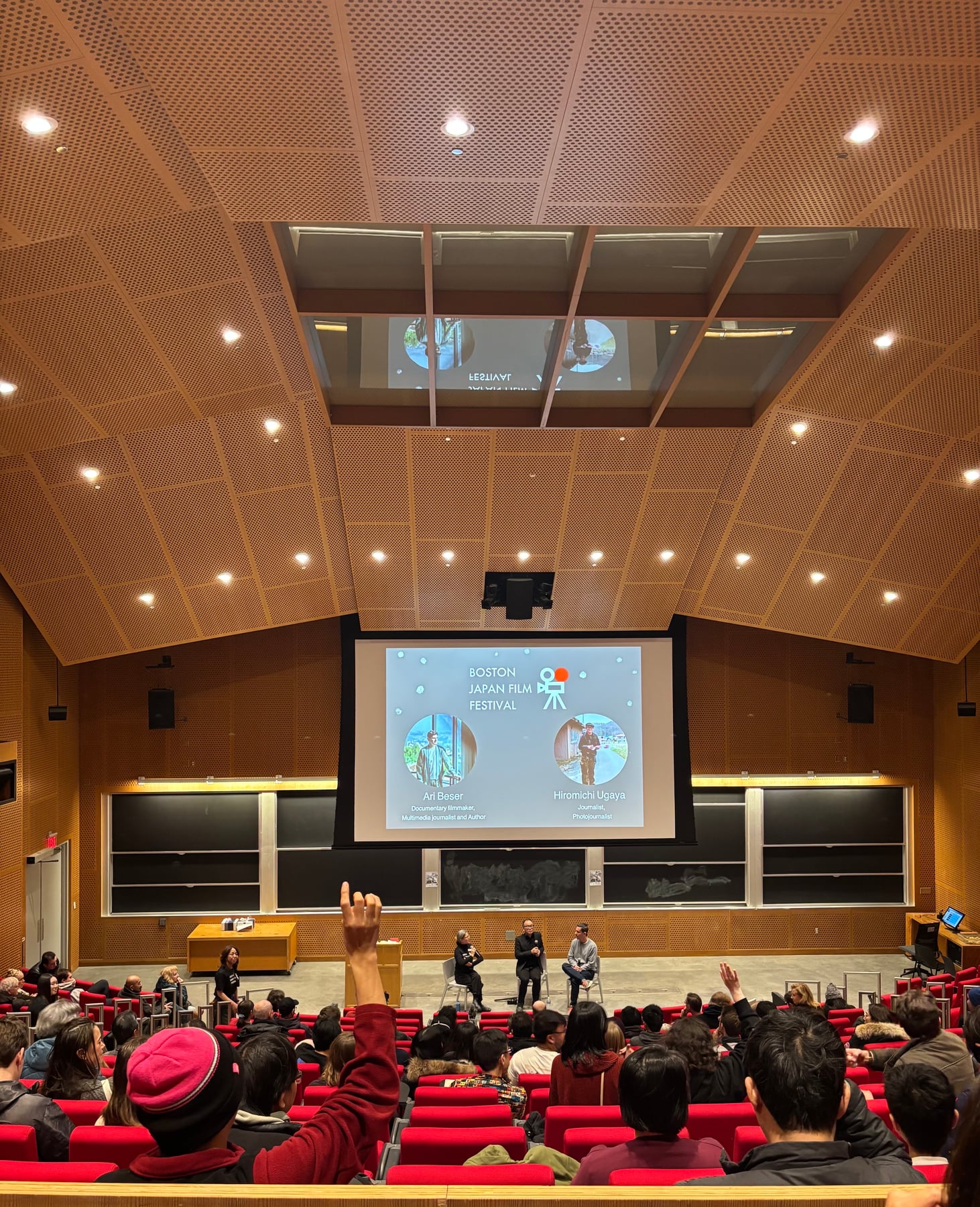 Boston Japan Film Festivalの会場後方から見た、対話の時間に手を挙げる観客と登壇者。